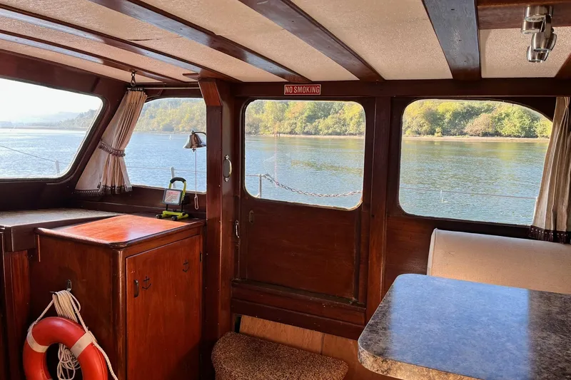 Slide: The Image of Interior of 1943 Shain-Monk cruiser with wood finish, overlooking serene water and trees. - 14