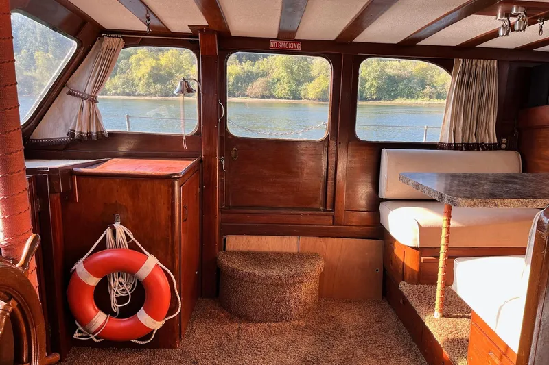 Slide: The Image of Interior of 1943 Shain-Monk cruiser with wood paneling, seating, and river view. - 17