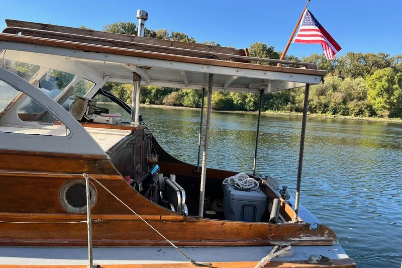 Slide: The Image of 1943 Shain-Monk 50 Twin Engine Cruiser on a serene river with American flag. - 25