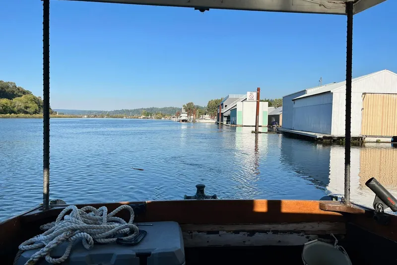 Slide: The Image of 1943 Shain-Monk 50 Twin Engine Cruiser on serene waterway, surrounded by boathouses. - 26