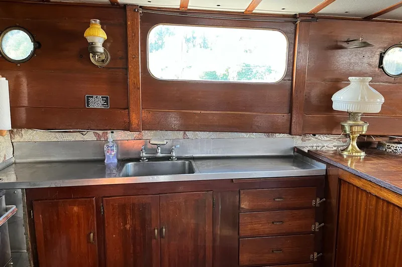 Slide: The Image of 1943 Shain-Monk cruiser interior with wooden cabinets, stainless steel sink, and vintage lamps. - 6