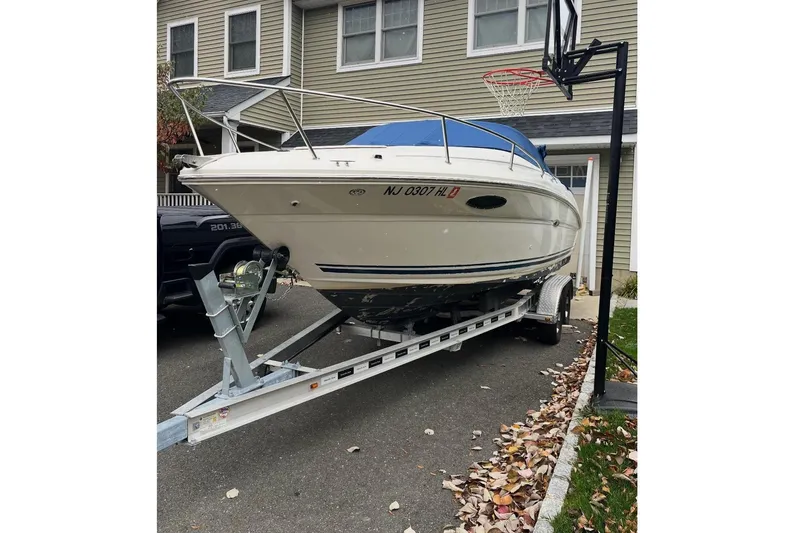 The Image of 2004 Sea Ray 215 Weekender boat on trailer, parked in residential driveway. - 0