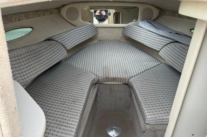 Slide: The Image of 2004 Sea Ray 215 Weekender cabin interior with patterned cushions and compact design. - 12