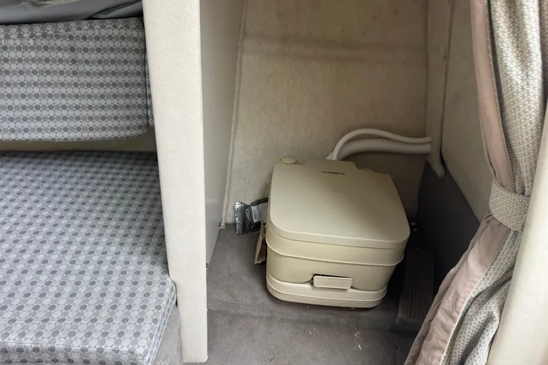 Slide: The Image of Interior of 2004 Sea Ray 215 Weekender with portable toilet and patterned seating. - 15