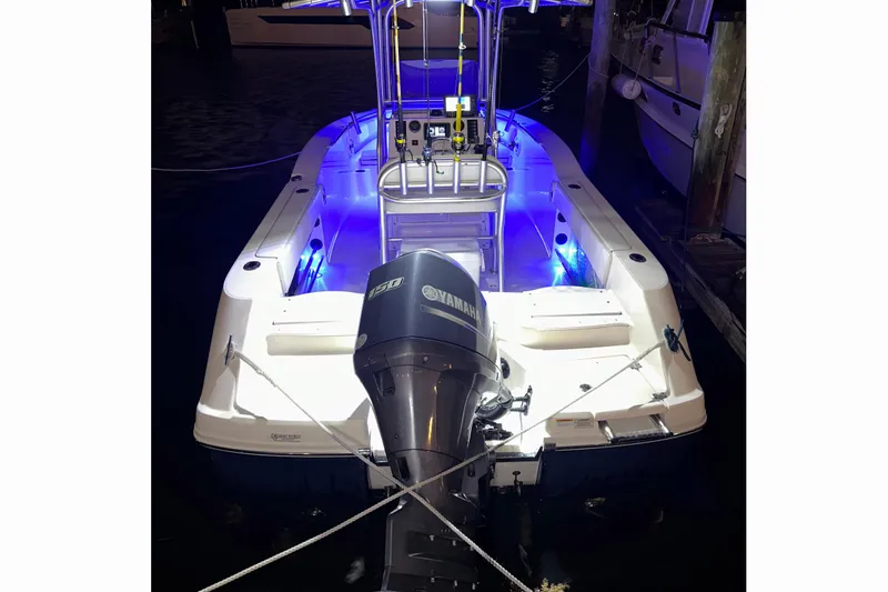 Slide: The Image of 2015 Robalo R200 Center Console boat with Yamaha engine, illuminated by blue lights at night. - 13