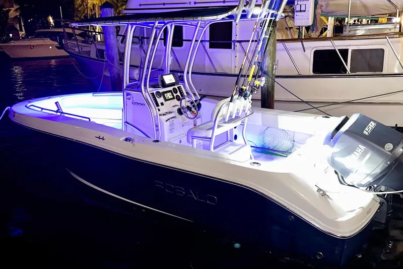 Slide: The Image of 2015 Robalo R200 Center Console boat illuminated at night, docked with fishing gear. - 14