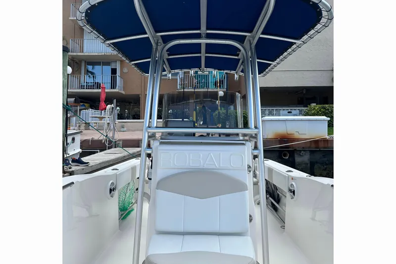 Slide: The Image of 2015 Robalo R200 Center Console boat with blue canopy docked at marina. - 5