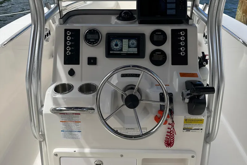 Slide: The Image of 2015 Robalo R200 Center Console boat dashboard with steering wheel and navigation controls. - 6