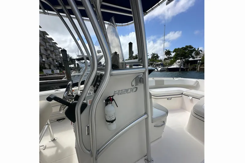 Slide: The Image of 2015 Robalo R200 Center Console boat docked, featuring sleek design and spacious seating. - 9