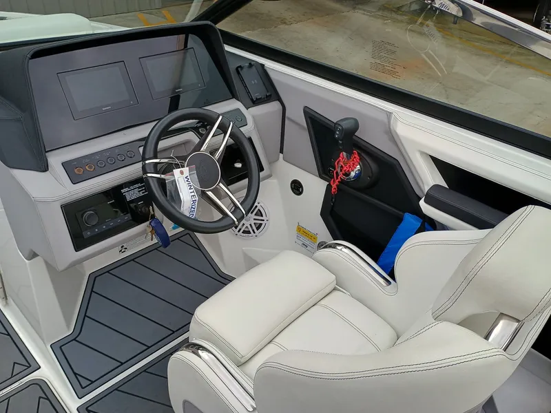Slide: The Image of 2022 Cobalt R4 boat cockpit with steering wheel, dashboard, and white captain's chair. - 6