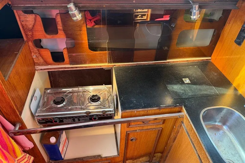 Slide: The Image of 1985 Jouet 950 yacht kitchen with stove, sink, and wooden cabinetry. - 11