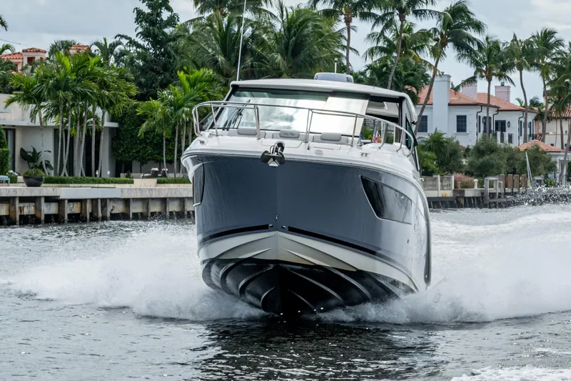 Slide: The Image of 2023 Sea Ray Sundancer 320 Outboard cruising on a scenic waterway with palm trees. - 15