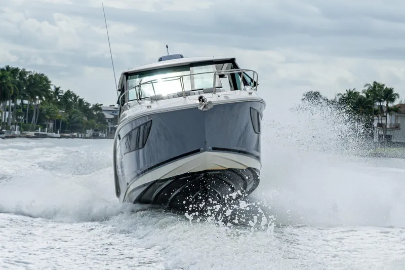Slide: The Image of 2023 Sea Ray Sundancer 320 Outboard cruising on water, creating dynamic waves. - 17