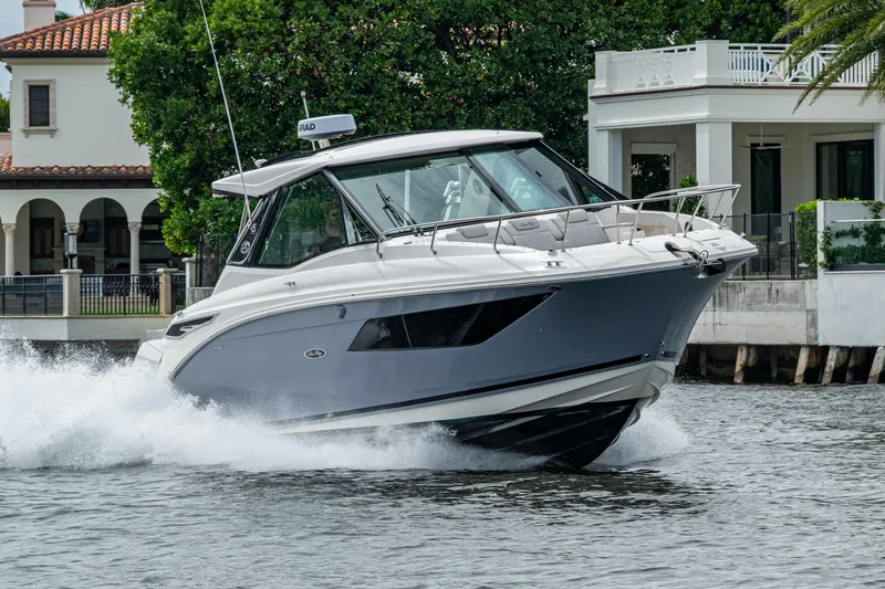 Slide: The Image of 2023 Sea Ray Sundancer 320 Outboard cruising near waterfront homes. - 23