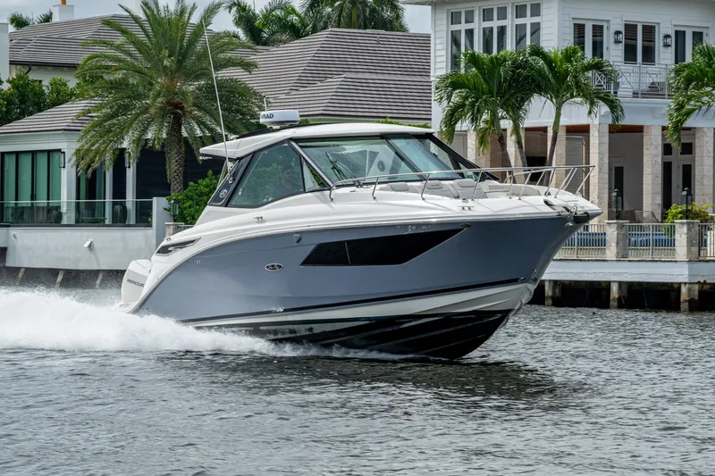 Slide: The Image of 2023 Sea Ray Sundancer 320 Outboard cruising near waterfront homes. - 24