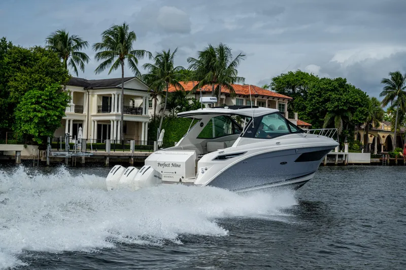 Slide: The Image of 2023 Sea Ray Sundancer 320 Outboard cruising near luxury waterfront homes. - 29