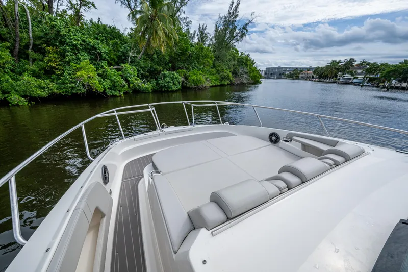 Slide: The Image of 2023 Sea Ray Sundancer 320 Outboard cruising on a scenic river with lush greenery. - 32