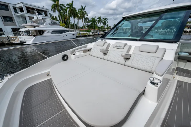 Slide: The Image of 2023 Sea Ray Sundancer 320 Outboard with luxurious seating, docked near waterfront homes. - 35