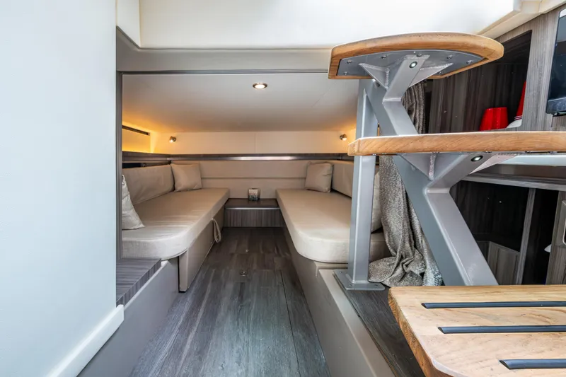 Slide: The Image of 2023 Sea Ray Sundancer 320 Outboard cabin interior with modern seating and wooden accents. - 41