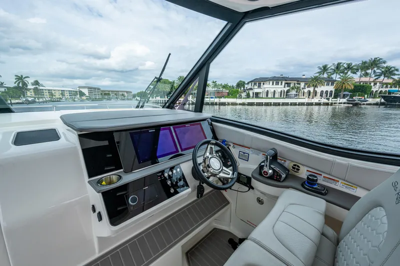 Slide: The Image of 2023 Sea Ray Sundancer 320 Outboard helm with modern controls and waterfront view. - 48