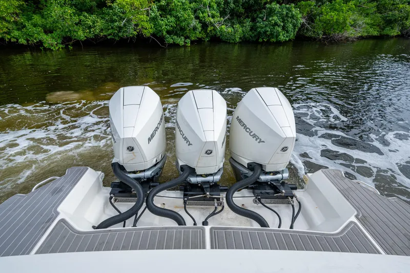 Slide: The Image of 2023 Sea Ray Sundancer 320 Outboard with triple Mercury engines on a calm river. - 59