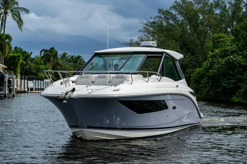 Slide: The Image of 2023 Sea Ray Sundancer 320 Outboard cruising on a scenic waterway with lush greenery. - 71