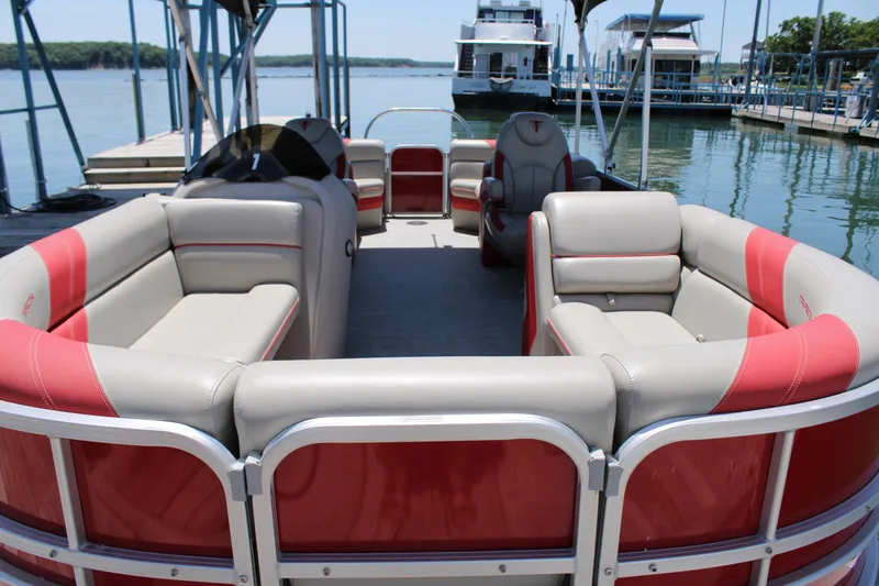 Slide: The Image of 2022 Trifecta 24RFLE pontoon boat with red and beige seating at a marina. - 4