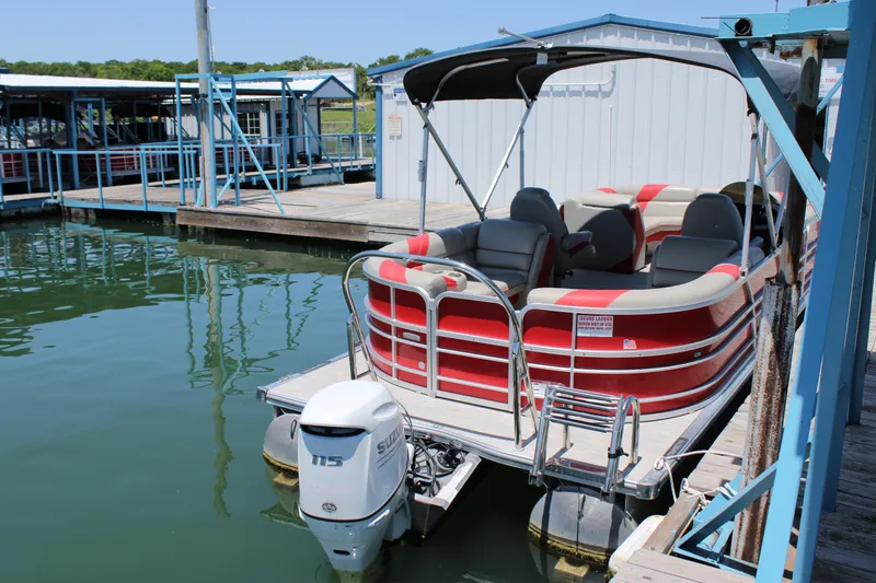 Slide: The Image of 2022 Trifecta 24RF LE pontoon boat docked at marina with Suzuki outboard motor. - 7
