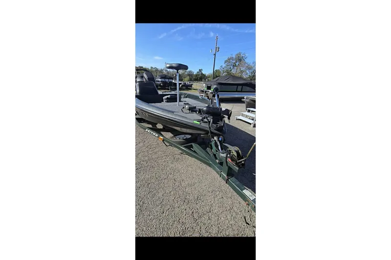 Slide: The Image of 1995 Nitro 170 TF boat on trailer, parked outdoors under clear sky. - 11