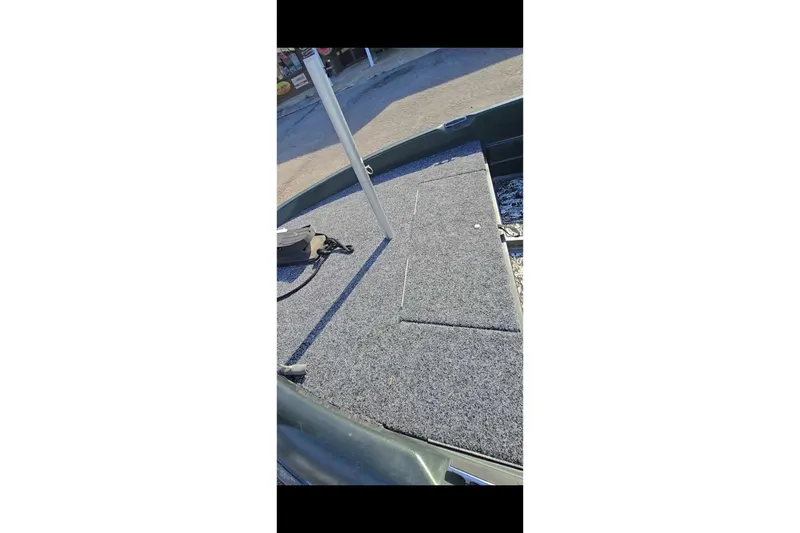 Slide: The Image of 1995 Nitro 170 TF boat deck with gray carpet and storage compartments. - 4