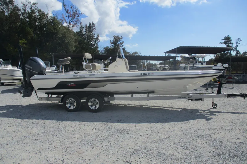 Slide: The Image of 2014 Skeeter SX240 boat on trailer in outdoor lot, clear sky background. - 4