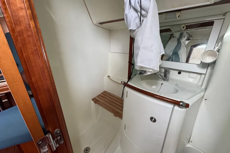 Slide: The Image of Interior of 2001 Beneteau Oceanis Clipper 361 with wooden table and blue seating. - 34