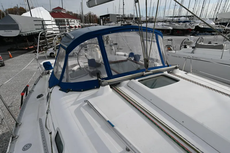 Slide: The Image of 2001 Beneteau Oceanis Clipper 361 sailboat docked in a marina, featuring a blue canopy. - 10