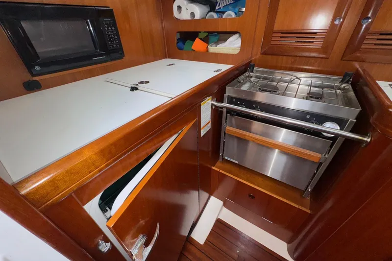 Slide: The Image of 2001 Beneteau Oceanis Clipper 361 yacht kitchen with stove, microwave, and wooden cabinetry. - 20