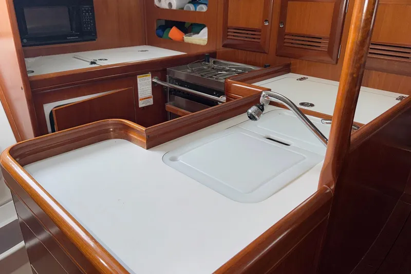Slide: The Image of 2001 Beneteau Oceanis Clipper 361 yacht kitchen with sink, stove, and microwave. - 23