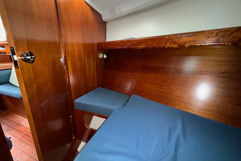 Slide: The Image of Interior cabin of 2001 Beneteau Oceanis Clipper 361 with wooden finish and blue upholstery. - 31