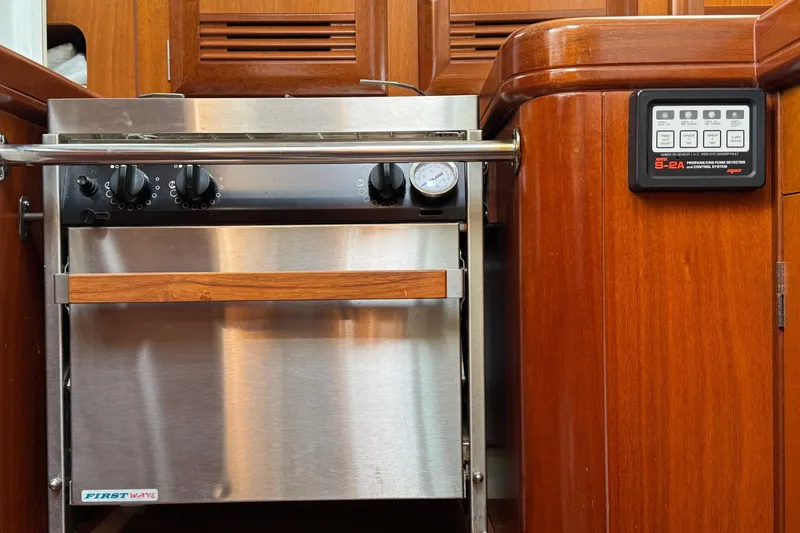 Slide: The Image of 2001 Beneteau Oceanis Clipper 361 yacht kitchen with stainless steel oven and wooden cabinetry. - 35