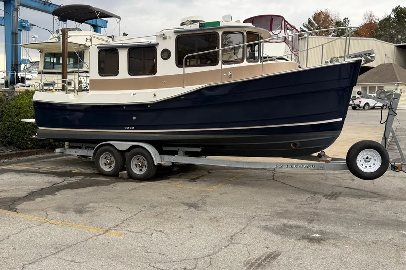 The Image of 2008 Ranger Tugs R-25 boat on trailer in a marina parking lot. - 1
