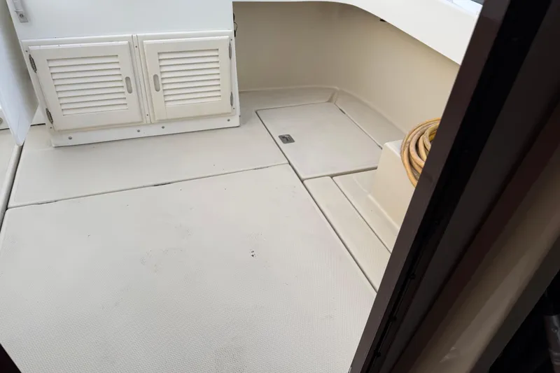 Slide: The Image of 2008 Ranger Tugs R-25 boat interior with storage compartments and coiled rope. - 17