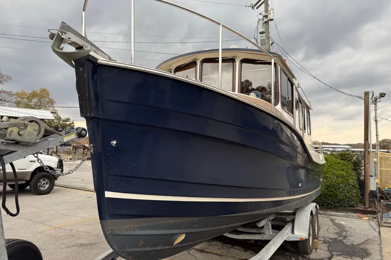 Slide: The Image of 2008 Ranger Tugs R-25 boat on trailer, parked outdoors under cloudy sky. - 3