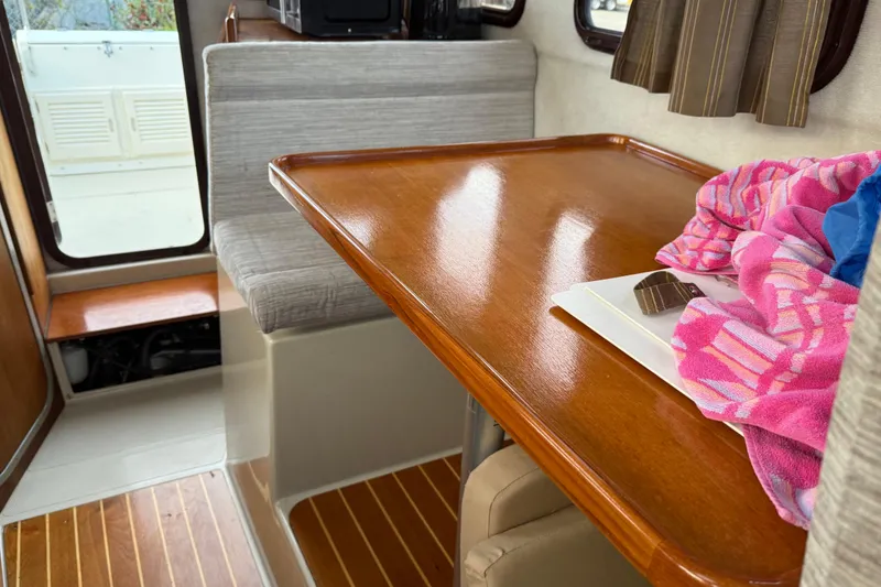 Slide: The Image of 2008 Ranger Tugs R-25 interior with wooden table, seating, and colorful fabric. - 31