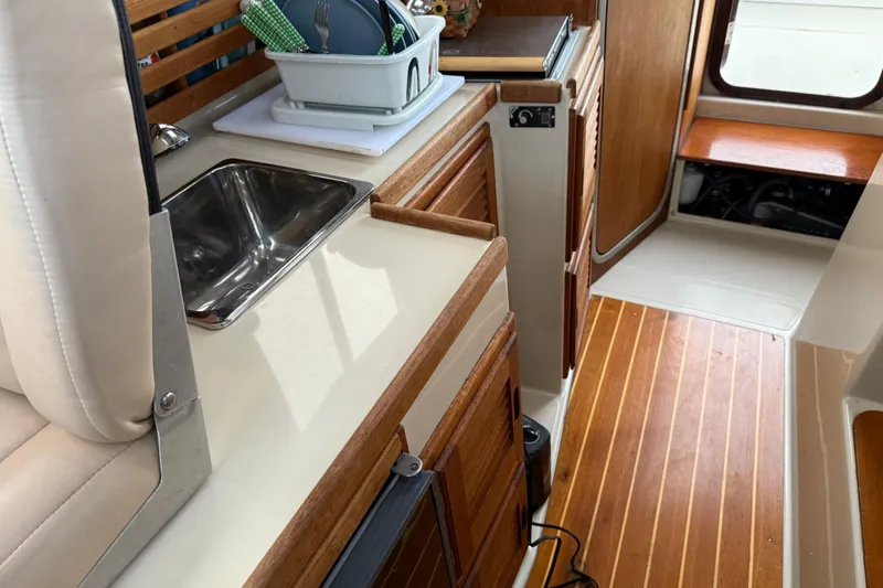 Slide: The Image of 2008 Ranger Tugs R-25 interior with wooden cabinetry and compact kitchen sink. - 32