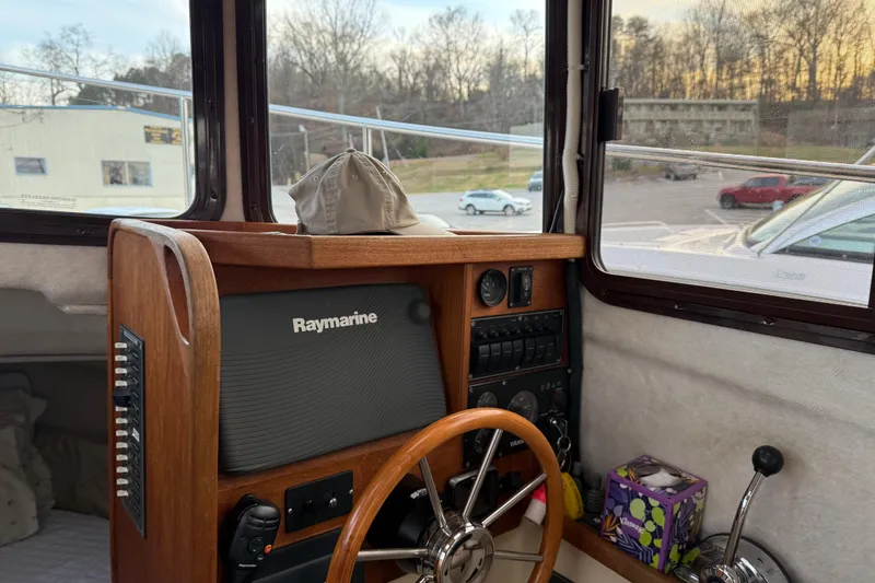 Slide: The Image of 2008 Ranger Tugs R-25 helm with Raymarine navigation system and wooden steering wheel. - 33