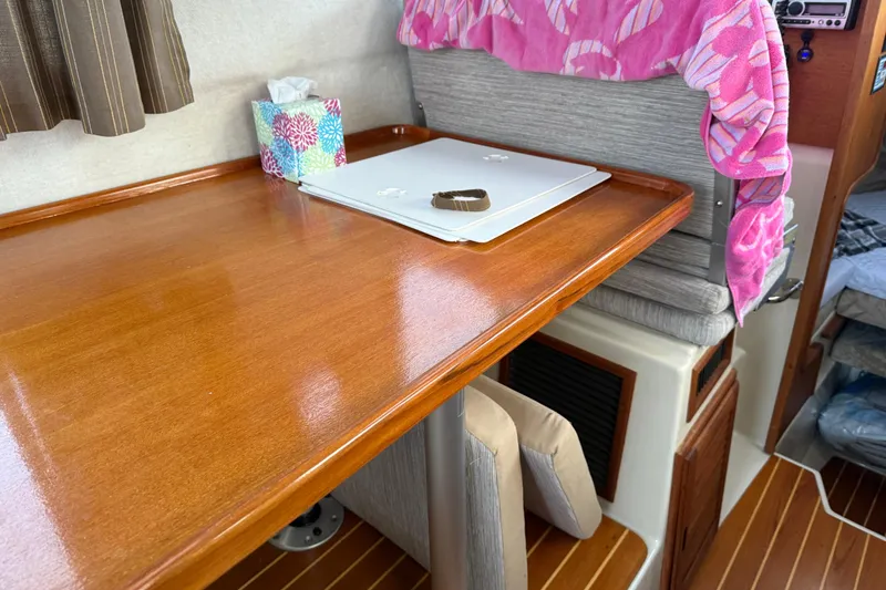 Slide: The Image of 2008 Ranger Tugs R-25 interior with wooden table, laptop, and colorful tissue box. - 39