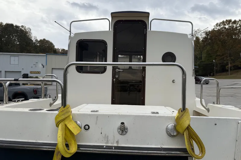 Slide: The Image of 2008 Ranger Tugs R-25 boat stern view with yellow ropes and metal railings. - 4