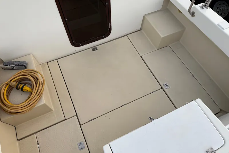 Slide: The Image of 2008 Ranger Tugs R-25 boat deck with storage compartments and coiled power cable. - 43