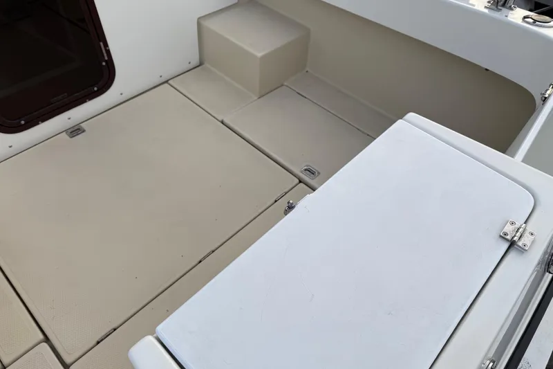 Slide: The Image of 2008 Ranger Tugs R-25 boat interior with beige flooring and storage compartments. - 44