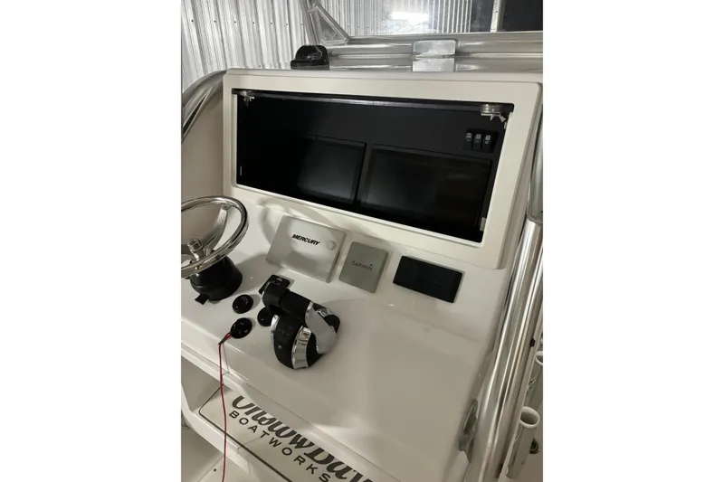 Slide: The Image of 2022 Onslow Bay 27 boat interior with rod holders and seating, showcasing sleek design. - 12