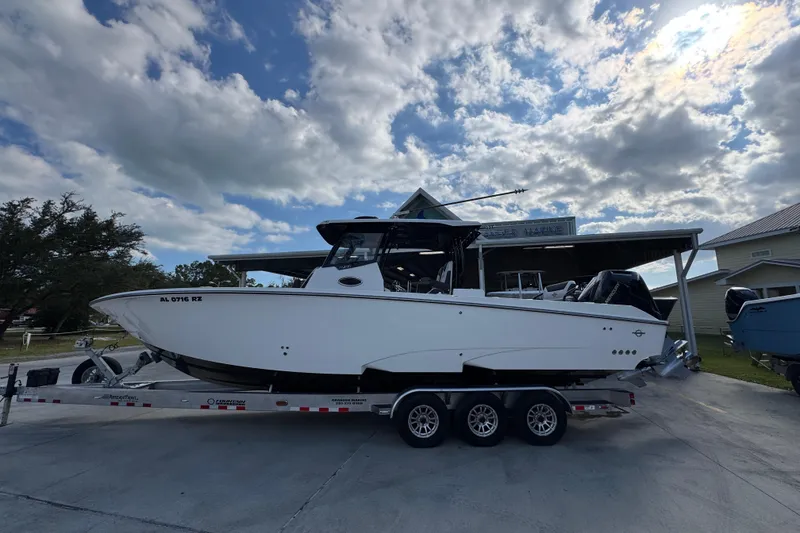 The Image of 2025 Fountain 32 NX boat on trailer under cloudy sky. - 1