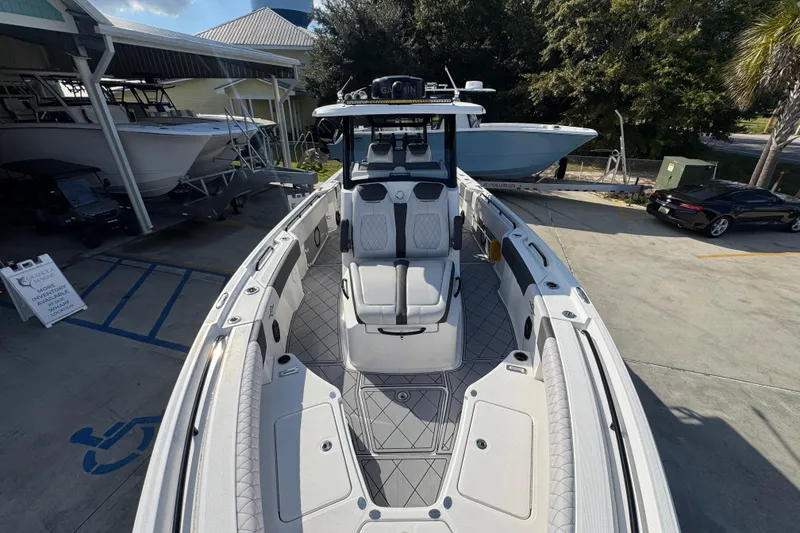 Slide: The Image of 2025 Fountain 32 NX boat with sleek design, docked at a marina. - 19